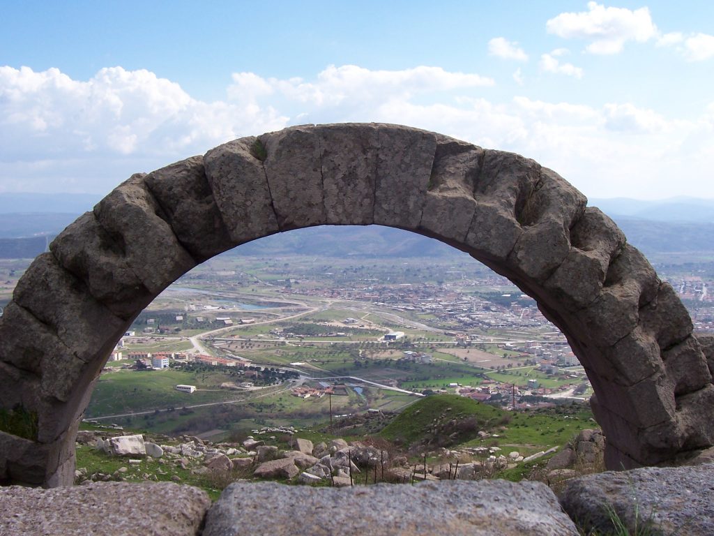 Pergamum was one of the Seven Churches of Revelation. An ancient stone arch frames the view of the valley far below