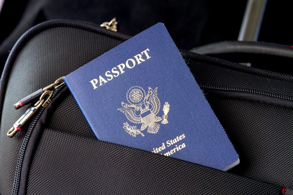 A US passport in the pocket of a rolling suitcase.